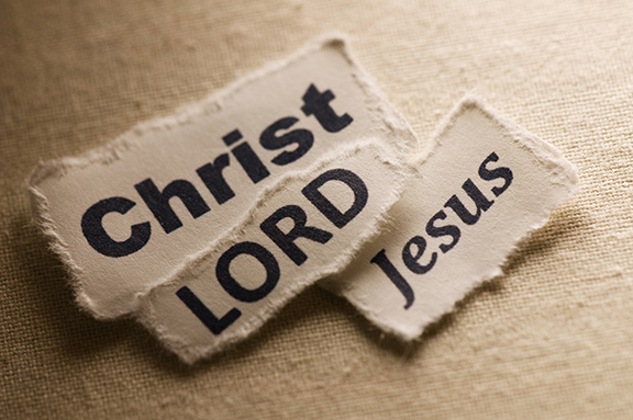 Torn paper snippets on textured background with the words Christ, Jesus, and LORD in bold lettering.