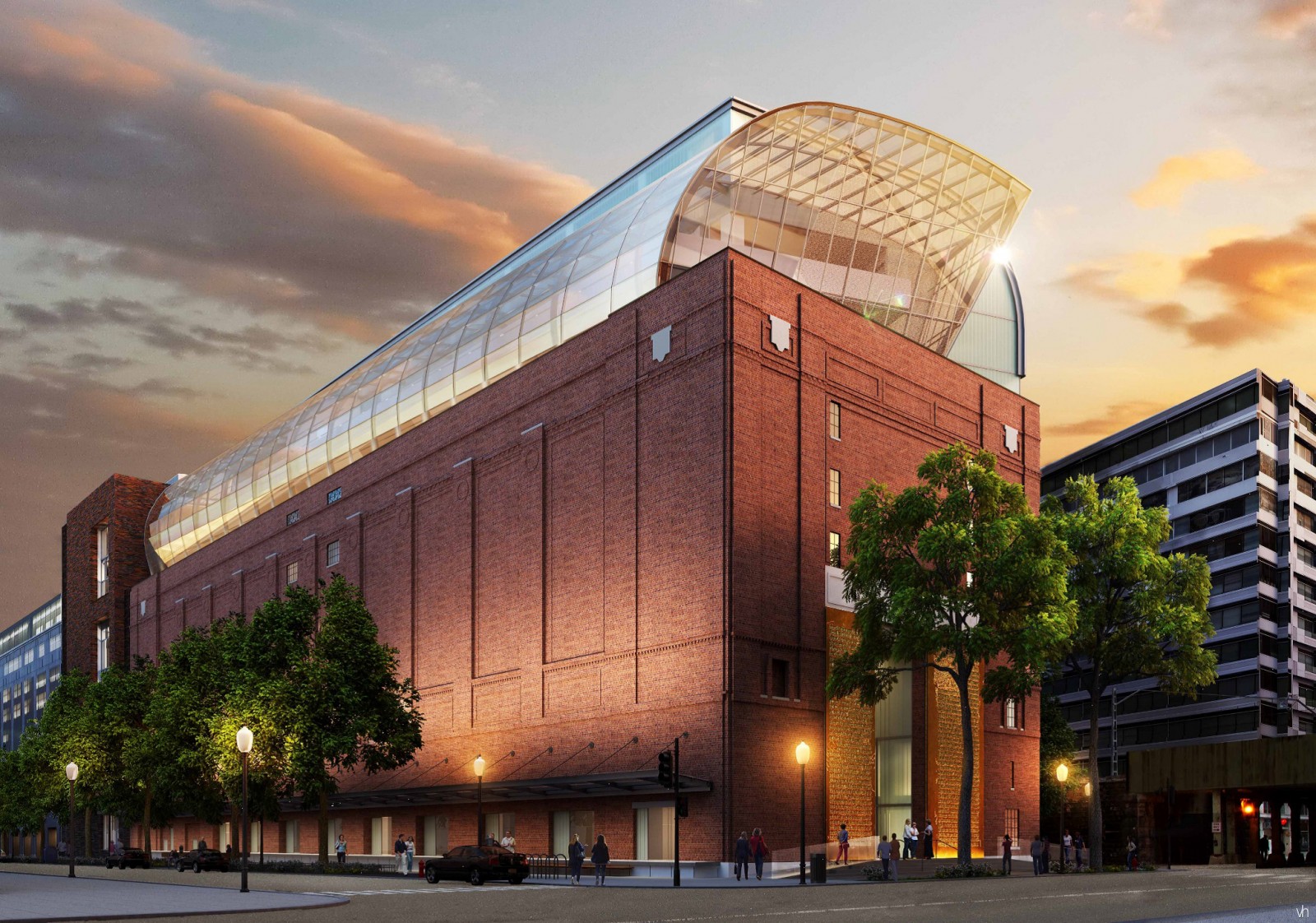 Modern museum with a glass dome extension on a historic brick building at sunset.