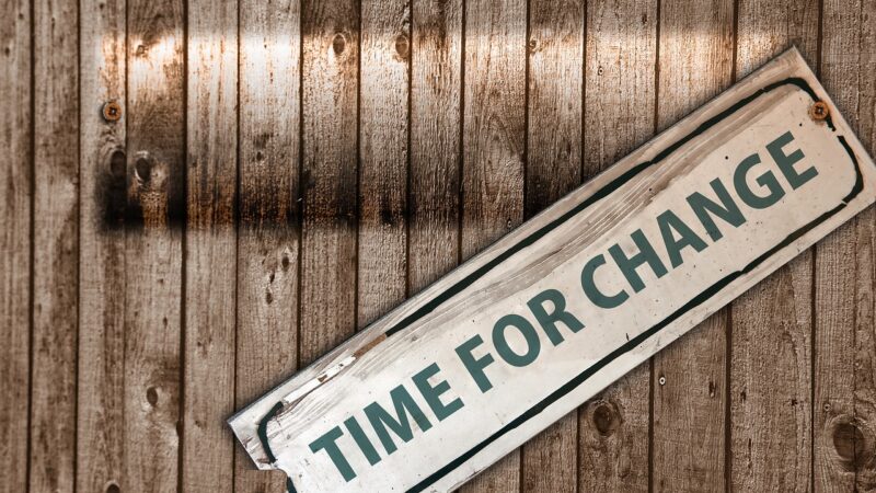 Sign reading 'Time for Change' on wooden background, symbolizing transformation and new beginnings.