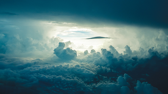 Dramatic cloudy sky with sunlight breaking through, creating a serene and mysterious atmosphere in the heavens.