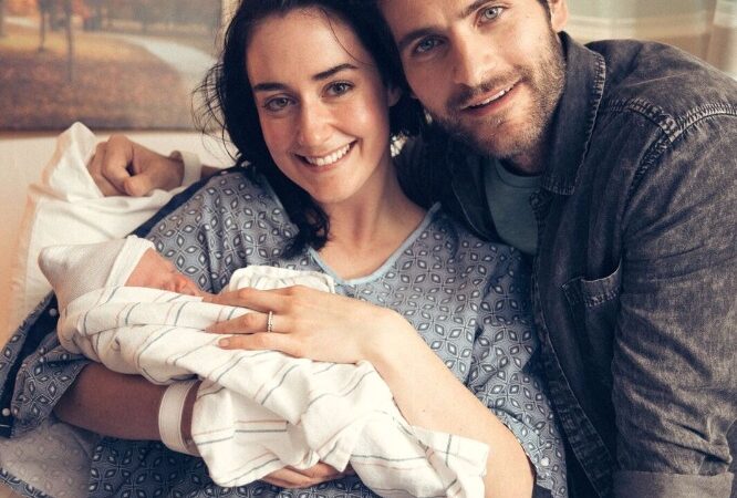 Smiling couple with newborn in hospital bed, symbolizing family joy and new beginnings.