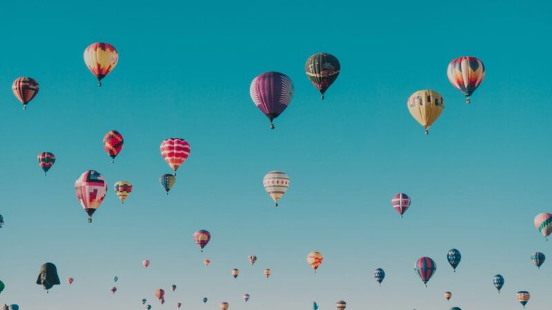 Colorful hot air balloons floating in a clear blue sky, creating a picturesque and serene scene.
