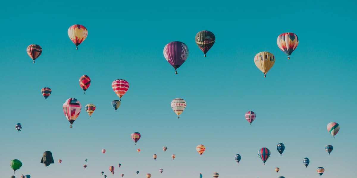 Colorful hot air balloons floating in a clear blue sky, creating a picturesque and serene scene.