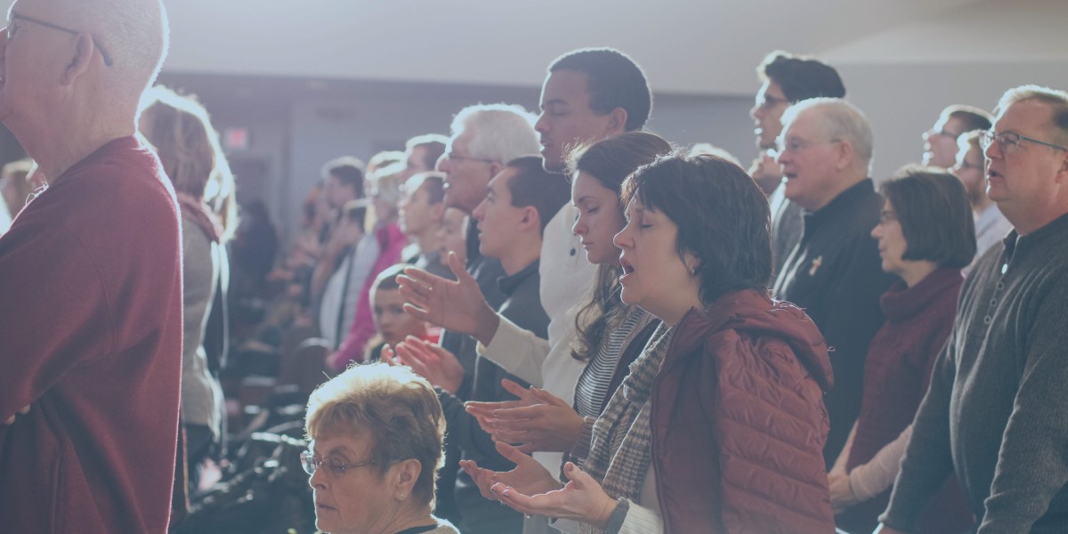 Congregation in a church praying and singing with reverence and devotion, highlighting unity and spirituality.