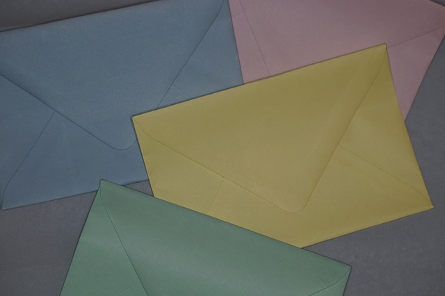 Colorful envelopes arranged on a flat surface, featuring blue, pink, yellow, and green hues.