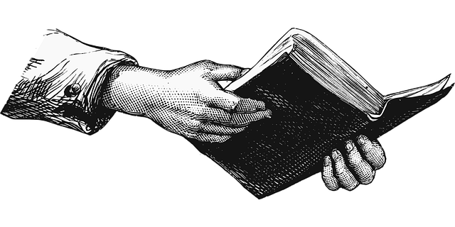 Illustrated hand holding an open book, vintage style drawing, black and white sketch.