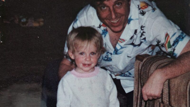 A child and adult smiling warmly in a cozy setting, capturing a joyful family moment.