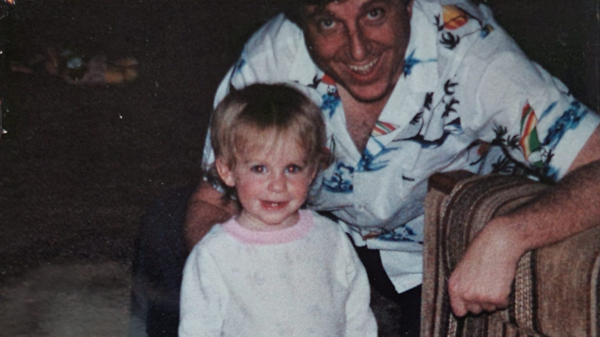 A child and adult smiling warmly in a cozy setting, capturing a joyful family moment.