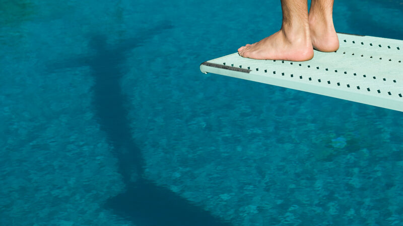 Male swimmer standing on diving board