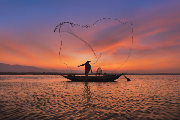 Asian Fisherman With His Wooden Boat In Nature River At The Early Morning Before Sunrise